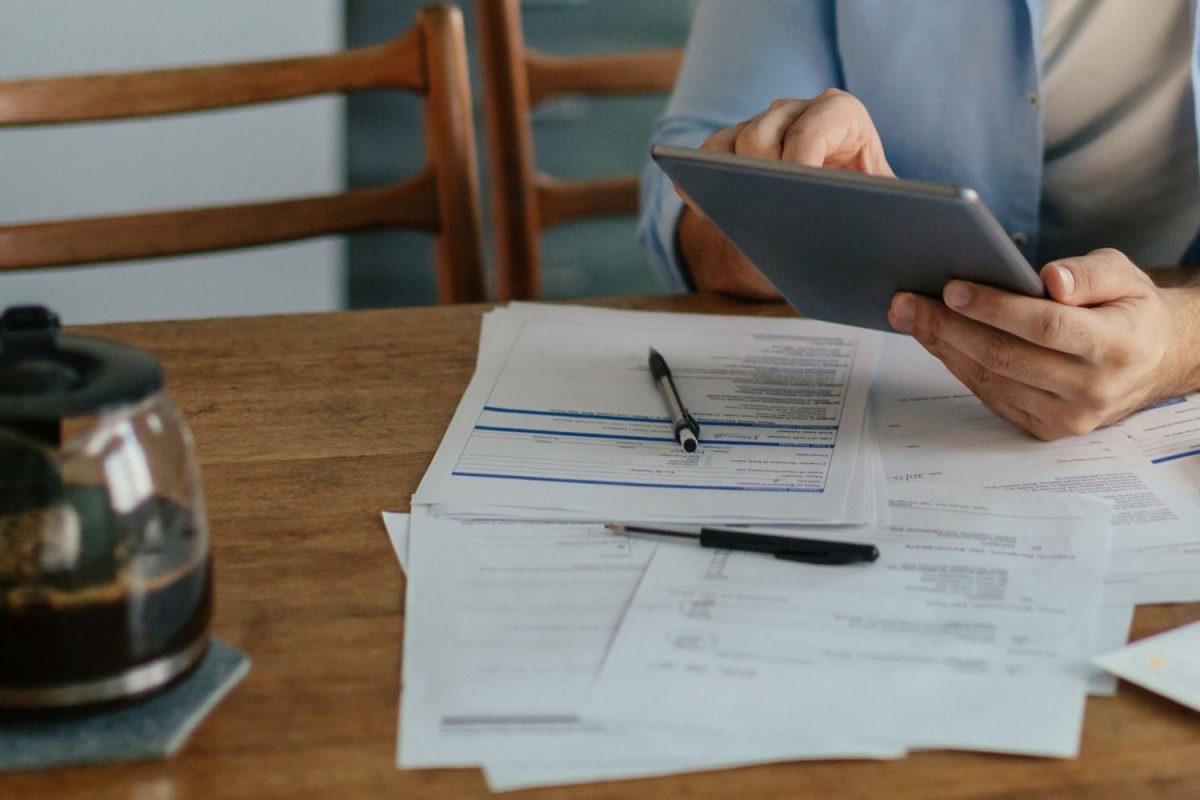 Person sits at a table reviewing bills.