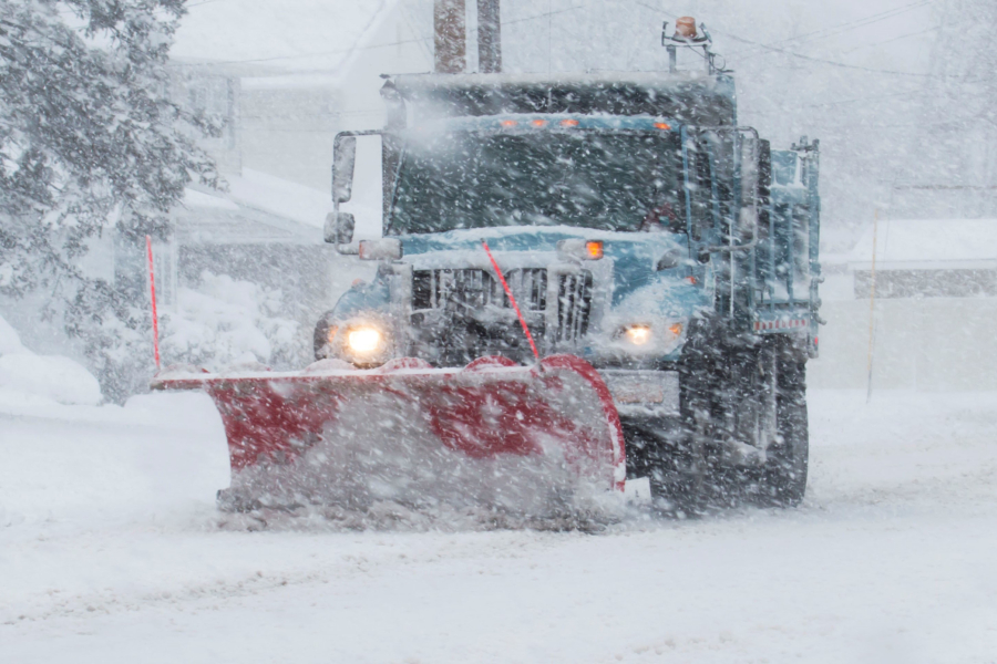 Snow plow clearing the road during a blizzard